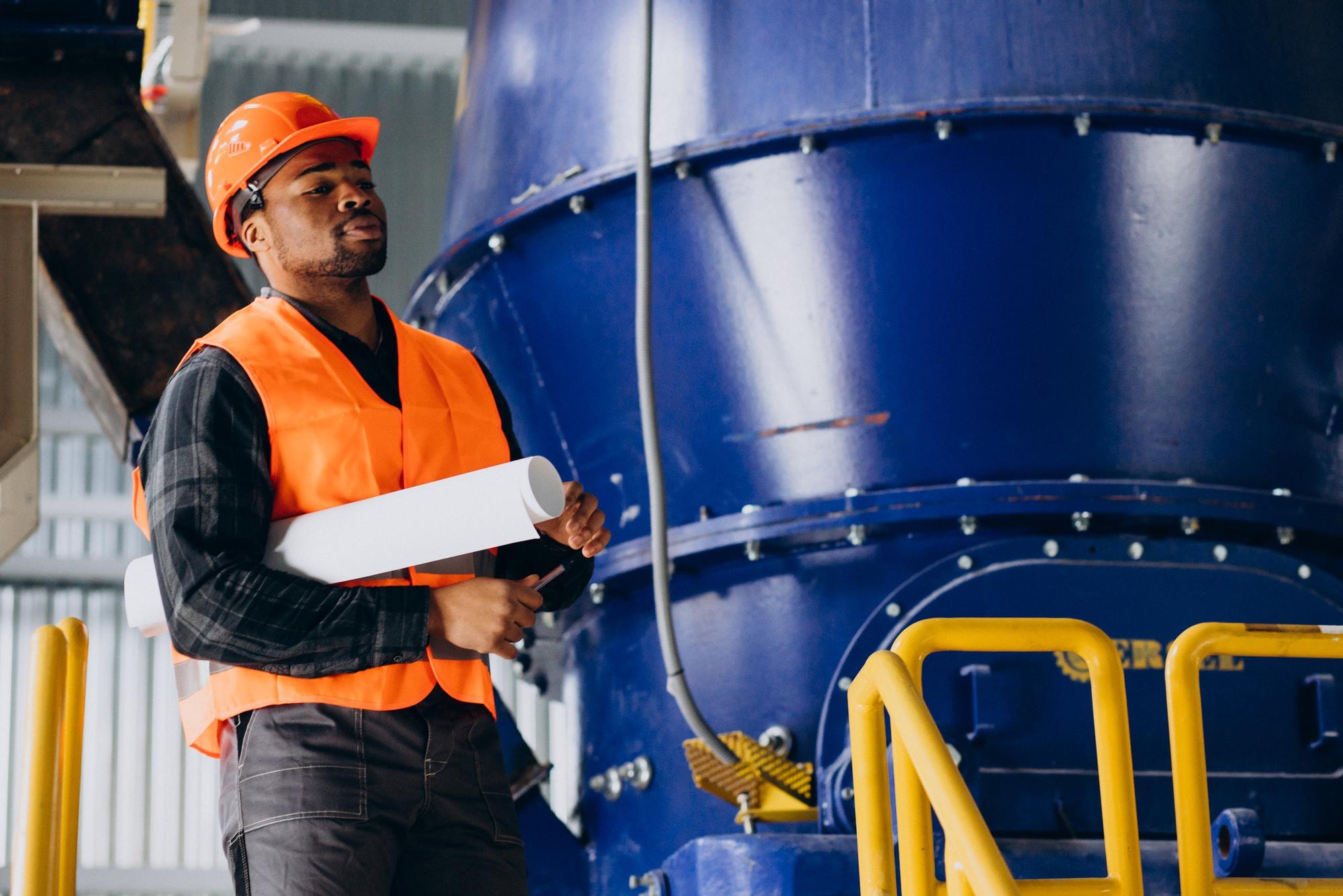 African industrial professional reviewing project plans inside a production facility